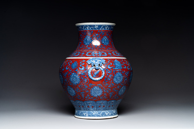 Vase de forme 'hu' en porcelaine de Chine en bleu, blanc et rouge de fer &agrave; d&eacute;cor de 'bajixiang' sur socle en bois, marque de Qianlong, 19&egrave;me