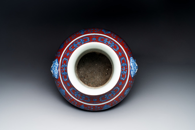 Vase de forme 'hu' en porcelaine de Chine en bleu, blanc et rouge de fer &agrave; d&eacute;cor de 'bajixiang' sur socle en bois, marque de Qianlong, 19&egrave;me