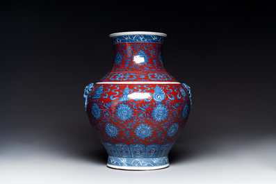 Vase de forme 'hu' en porcelaine de Chine en bleu, blanc et rouge de fer &agrave; d&eacute;cor de 'bajixiang' sur socle en bois, marque de Qianlong, 19&egrave;me
