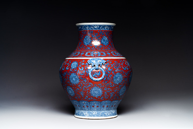 Vase de forme 'hu' en porcelaine de Chine en bleu, blanc et rouge de fer &agrave; d&eacute;cor de 'bajixiang' sur socle en bois, marque de Qianlong, 19&egrave;me