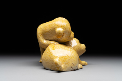 A Chinese monochrome yellow-glazed group of two playing dogs, 19th C.