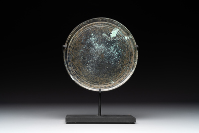 A bronze mirror, a bracelet with a royal or noble emblem and a bronze bracelet with two tiger heads, Cambodia, 12th C.