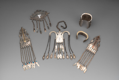 Two silver bracelets, two pendants with carnelian stones, a silver back ornament and a silver capstone, Turkmenistan, 19/20th C.