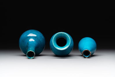 Three Chinese monochrome turquoise-glazed vases with two wooden stands, Kangxi and later