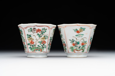 A Chinese wucai rouleau vase and a pair of octagonal cups with floral design, Transitional period/Kangxi