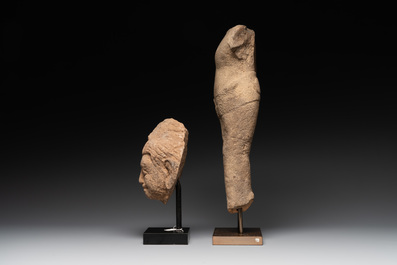 A sandstone torso and a Buddha head, Cambodia, late Khmer period, 13/14th C.