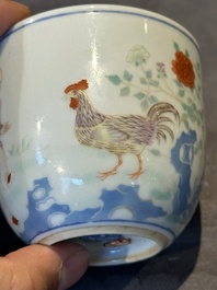 A Chinese famille rose cup with a boy and a rooster on wooden base, Qianlong mark, 20th C.