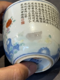 A Chinese famille rose cup with a boy and a rooster on wooden base, Qianlong mark, 20th C.