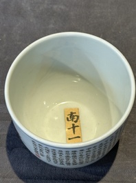 A Chinese famille rose cup with a boy and a rooster on wooden base, Qianlong mark, 20th C.