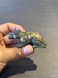 A rare Chinese gold and silver-inlaid bronze paperweight in the shape of a tapir '貘', Warring States period