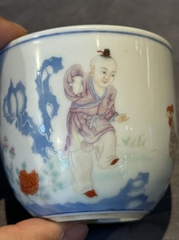 A Chinese famille rose cup with a boy and a rooster on wooden base, Qianlong mark, 20th C.