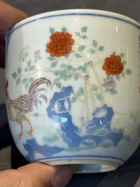 A Chinese famille rose cup with a boy and a rooster on wooden base, Qianlong mark, 20th C.