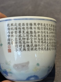 A Chinese famille rose cup with a boy and a rooster on wooden base, Qianlong mark, 20th C.