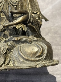 A Chinese bronze Guanyin, Ming and a Tibetan polychrome plaster relief, 19th C.