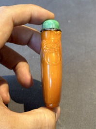A rare Chinese amber snuff bottle with lion handles, 19th C.