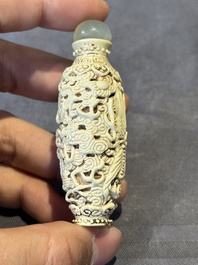 A Chinese moulded cream-glazed 'dragon and phoenix' snuff bottle, Jiaqing mark, 19th C.