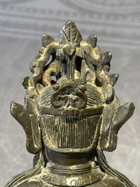 A Chinese bronze Guanyin, Ming and a Tibetan polychrome plaster relief, 19th C.
