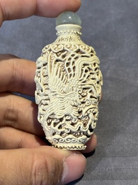 A Chinese moulded cream-glazed 'dragon and phoenix' snuff bottle, Jiaqing mark, 19th C.