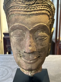 A Thai red sandstone head of Buddha and a lacquered and gilt stone head of Buddha, possibly Ayutthaya period, 15th C.