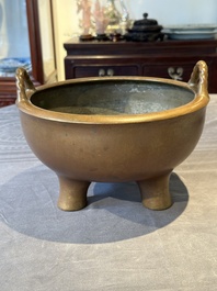 A large Chinese bronze tripod censer with two handles, 19th C.