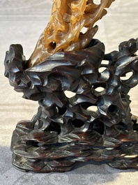 A Chinese buffalo horn carving of a landscape with a pagoda on wooden stand, Qing