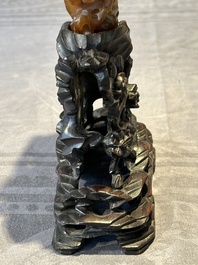 A Chinese buffalo horn carving of a landscape with a pagoda on wooden stand, Qing