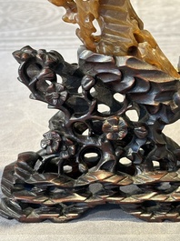 A Chinese buffalo horn carving of a landscape with a pagoda on wooden stand, Qing