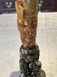 A Chinese buffalo horn carving of a landscape with a pagoda on wooden stand, Qing