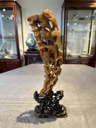 A Chinese buffalo horn carving of a landscape with a pagoda on wooden stand, Qing