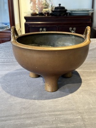 A large Chinese bronze tripod censer with two handles, 19th C.