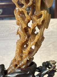 A Chinese buffalo horn carving of a landscape with a pagoda on wooden stand, Qing