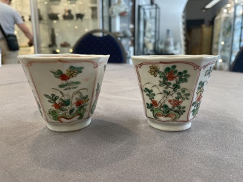 A Chinese wucai rouleau vase and a pair of octagonal cups with floral design, Transitional period/Kangxi