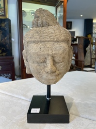 A sandstone torso and a Buddha head, Cambodia, late Khmer period, 13/14th C.
