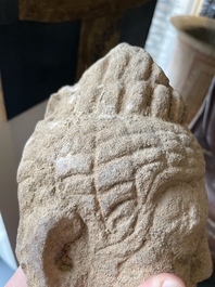 A sandstone torso and a Buddha head, Cambodia, late Khmer period, 13/14th C.