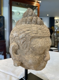 A sandstone torso and a Buddha head, Cambodia, late Khmer period, 13/14th C.