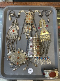 Two silver bracelets, two pendants with carnelian stones, a silver back ornament and a silver capstone, Turkmenistan, 19/20th C.
