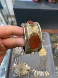 Two silver bracelets, two pendants with carnelian stones, a silver back ornament and a silver capstone, Turkmenistan, 19/20th C.