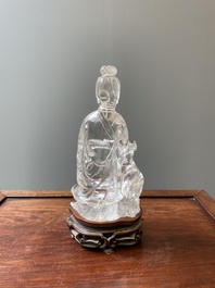 A Chinese rock crystal sculpture of Lan Caihe on wooden stand, 19th C.