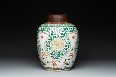 A Chinese famille verte jar with floral design and a wooden cover, Kangxi