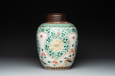 A Chinese famille verte jar with floral design and a wooden cover, Kangxi