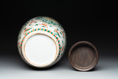 A Chinese famille verte jar with floral design and a wooden cover, Kangxi