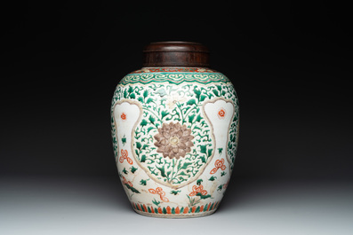 A Chinese famille verte jar with floral design and a wooden cover, Kangxi