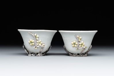 A pair of Chinese Dehua blanc de Chine relief-decorated famille rose 'prunus' cups, 19th C.