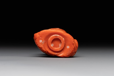 A Chinese carved red coral 'dragon' snuff bottle on wooden stand, 19/20th C.