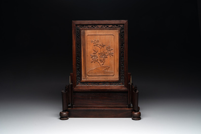 A large Chinese carved wooden table screen with a fine famille rose 'landscape' plaque, 19th C.