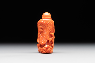 A Chinese carved red coral 'dragon' snuff bottle on wooden stand, 19/20th C.