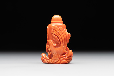 A Chinese carved red coral 'dragon' snuff bottle on wooden stand, 19/20th C.