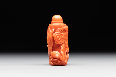 A Chinese carved red coral 'dragon' snuff bottle on wooden stand, 19/20th C.