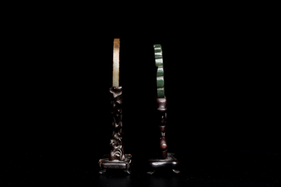 A Chinese russet jade 'bi' disc and a spinach-green flower-shaped pendant on wooden stands, Ming and Qing
