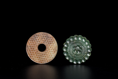 A Chinese russet jade 'bi' disc and a spinach-green flower-shaped pendant on wooden stands, Ming and Qing